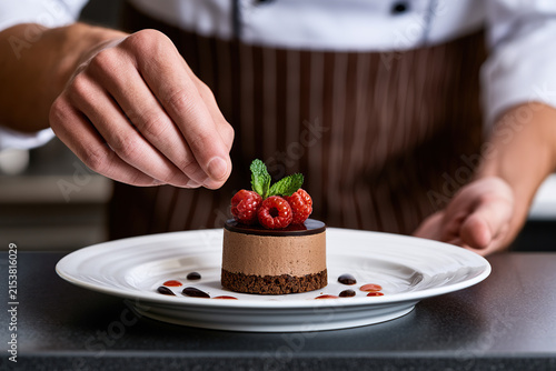 Chef's hand with delicious dessert in dish