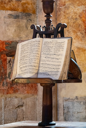 Obraz na płótnie Open Latin hymnal with Gregorian chant resting on wooden church lectern