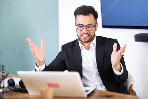 Fotografía Man sitting at desk is working on laptop computer