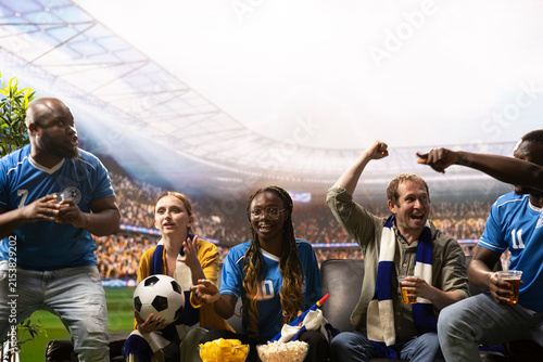 Fotografie High-fidelity sports broadcasting immerses viewers as soccer fans on the couch eat popcorn, cheer for their team and react to action across the football field in a stadium match experience from home