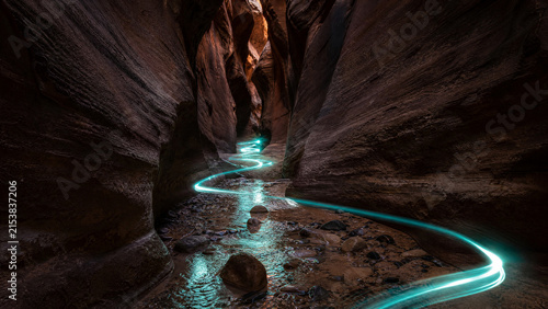 Professional long exposure photography of neon teal light trails in Red Rock Slot Canyon
