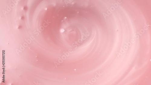 Pearlescent pink liquid soap, shower gel swirl texture, surface of liquid fluid, background, shampoo texture, body care cosmetic, texture of liquid washing gel, soap backdrop top view, rotating. 
