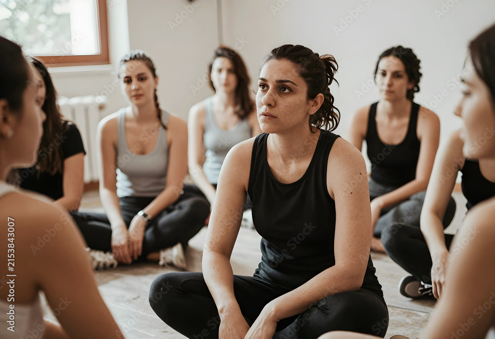 Fototapeta premium Group of women sitting on the floor in a circle focused on a yoga or meditation session wellness and mindfulness, the participants are focused, embodying wellness and mindfulness concepts
