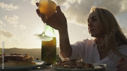 Young Woman Enjoys Federweisser young wine served with Onion tart Zwiebelkuchen. Rhine Valley terraced vineyards Germany