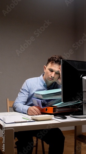 Foto Man feeling exhausted and overwhelmed, resting his head on his hand while sittin