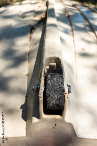 Overturned boat on the lake shore with wheel