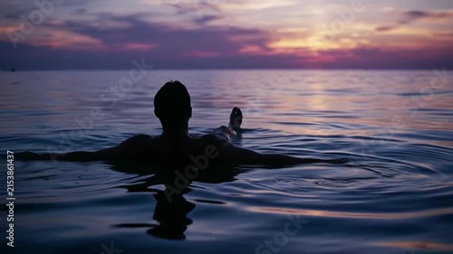 Man floating in sea sunset 4K Video