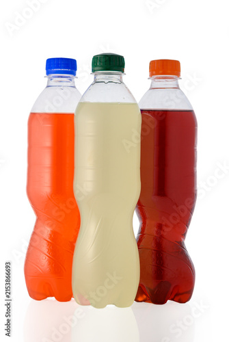 Three unlabeled plastic bottles with colorful drinks grouped together on white