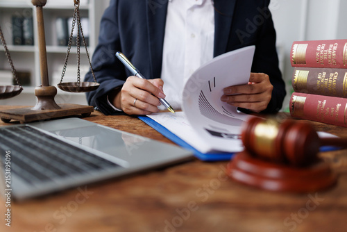 Legal professional reviewing documents at office desk, symbolizing justice and law enforcement