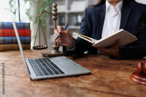 Lawyer working on legal research and planning with laptop, scales of justice, and law books in office