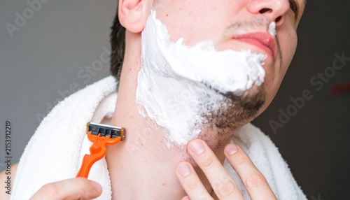 Young Man Preparing to Shave Beard with Manual Razor and Shaving Cream