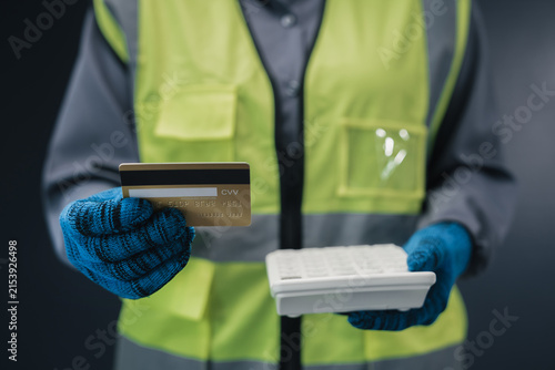 Construction budget calculation industrial payment concept worker holding credit card calculator estimating material purchasing cost supply chain finance warehouse procurement company expense