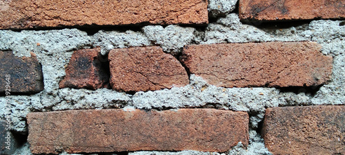 Weathered red clay brick texture with cement mortar.