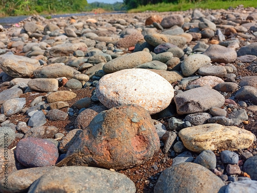 Foto Close up view of smooth river stones and pebbles scattered along a dry riverbed