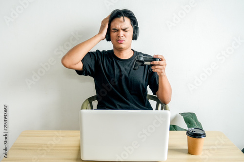 Konstfotografi Stressed Young Man Wearing Headphones Expressing Defeat While Playing Video Game