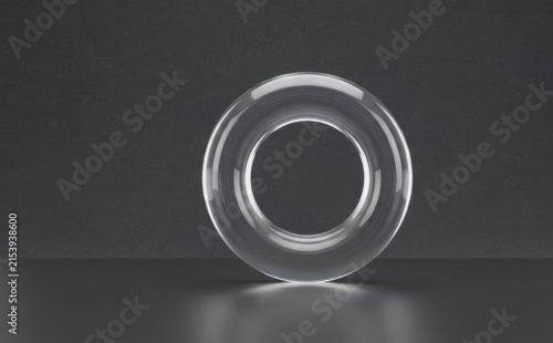 Transparent glass torus shape geometric object 3d render against a dark minimalist studio background for modern design concepts