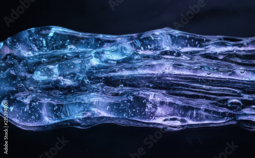 Blue and purple shimmering cosmetic gel slime texture close up representing futuristic skincare science and beauty innovation