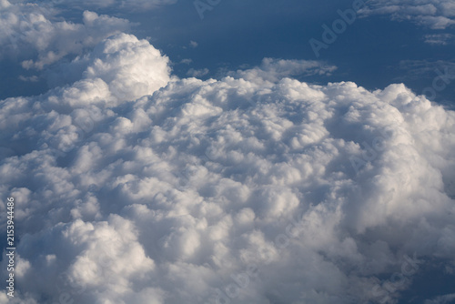 Stratosphere, a view of clouds from an airplane window. Cumuliform cloudscape on sky. Flying over the land.
