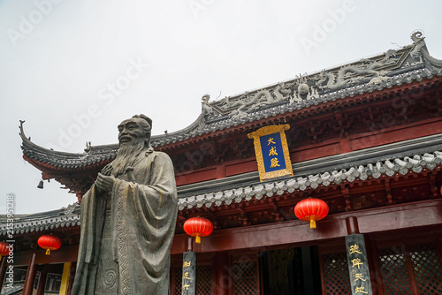Foto A Confucius statue is displayed beneath a traditional roofline at the Confucius Temple in Nanjing
