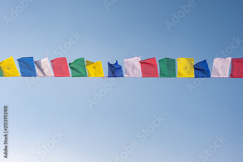 Konstfotografi Prayer flags blowing by the wind isolated on blue sky