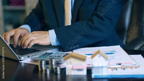 Businessman typing on laptop to prepare property quotation reports and housing price proposals.