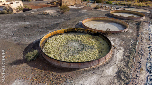 Aerial view of Ruinas de Planta de Sulfato de Aluminio featuring large circular industrial tanks in an arid landscape Calingasta, San Juan, Argentina.