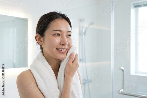 白いタオルで顔を拭く若い女性（スキンケア・保湿・美容・洗顔）