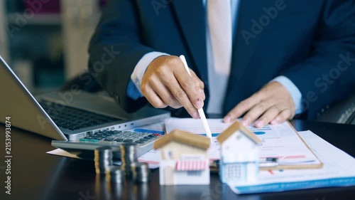 Businessman reviewing and flipping financial report pages to verify accuracy for a client presentation.