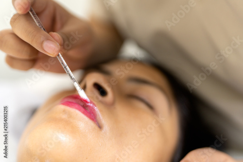 Woman receiving lip treatment at beauty clinic