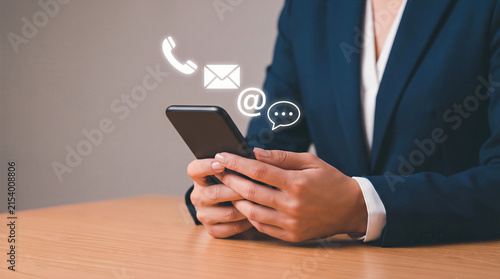 Professional using a smartphone with floating digital icons for chat, email, phone, and web. Customer service and contact concept