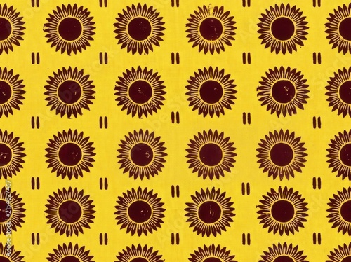 Seamless pattern with stylized sunflowers and vertical dashes on a yellow background
