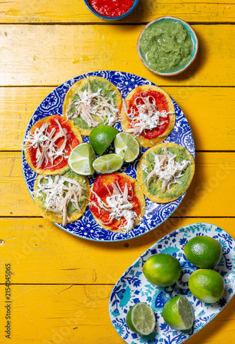 Delicious Mexican chalupas topped with chicken, served on colorful ceramics for Independence Day celebrations