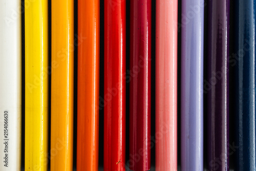close-up of colored pencil barrels neatly lined up in colour wheel order, concept of creativity and education