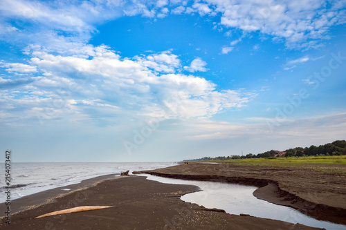 Tidal Channel Flowing into the Ocean on Sandy Beach