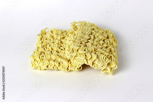 Uncooked instant noodles stacked on a clean white background