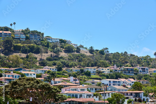 Canvastavla Scenic California coastal hillside town with luxury houses and villas terraced on a green mountain slope under a clear blue sky on a sunny day