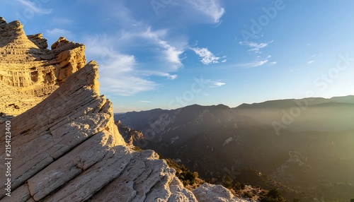 Ancient stone wall with yellow flowers and distant mountains.