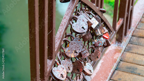 Cuadro en lienzo Locks attached to a bridge in a park near water in a city during a cloudy day