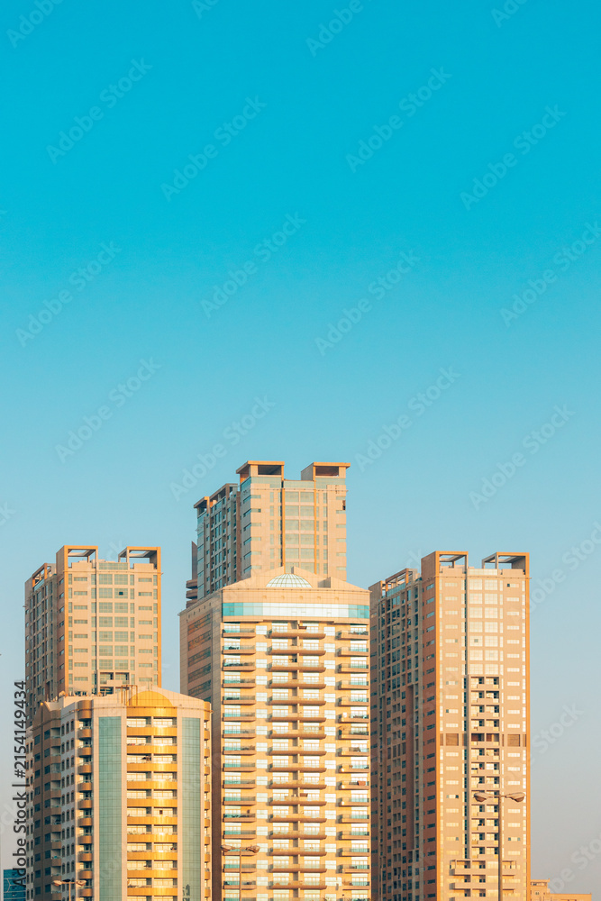 Fototapeta premium New Residential Multi-storey Houses. Cityscape Skyline In Sunny Spring Evening On Blue Sky. Real Estate, Development Industry. UAE