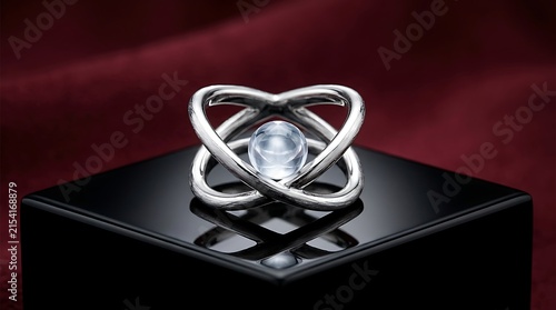Elegant silver ring featuring glowing crystal sphere floating inside circular orbital structure.