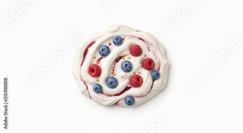 Distant shot of 5 to 10 wild blueberries and raspberries elegantly resting on thick white cherry Greek yogurt
