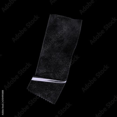 Black duct tape strip with horizontal shiny crease and textured surface on black background, realistic adhesive tape isolated