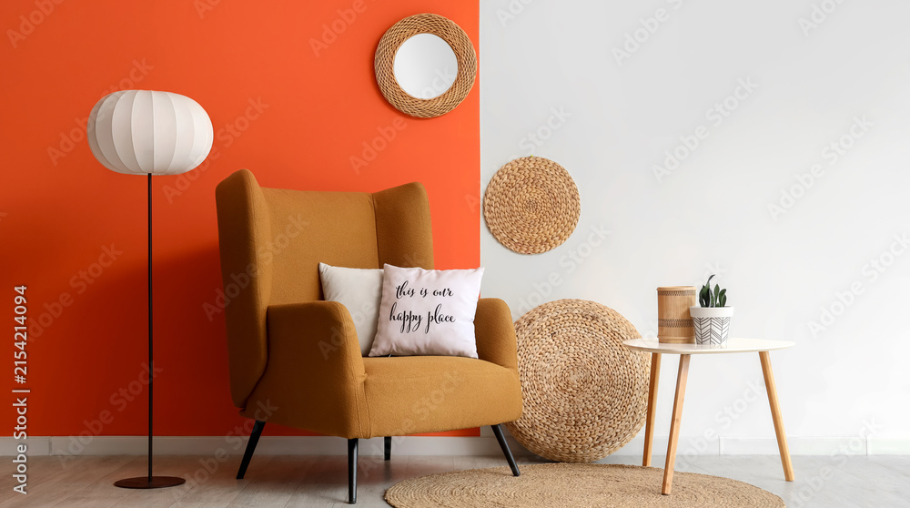 Obraz premium Cozy living room interior with a mustard armchair, floor lamp, and decorative elements against a two-tone wall