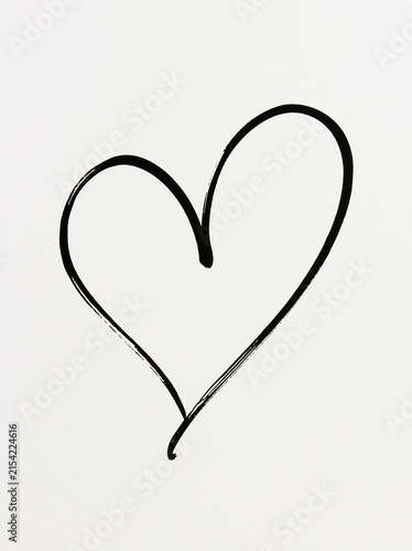 Simple hand drawn black brush stroke outline heart shape on plain textured white paper background represents love romance and Valentines day romantic concept