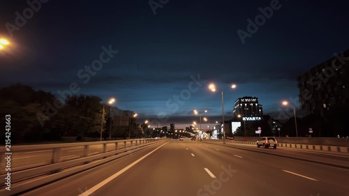 Evening urban highway commute with taxi and lit streetlights under deep blue