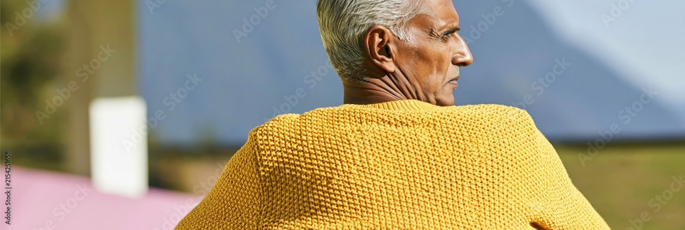 Fototapeta premium Senior man profile wearing yellow sweater outdoors with blurred background for healthcare banner and wellbeing design