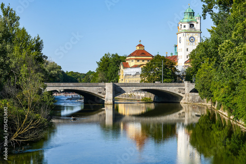 The historic Müller Volksbad, with its magnificent Art Nouveau architecture, and the stone Ludwigsbrücke are picturesquely reflected in the waters of the Isar in Munich