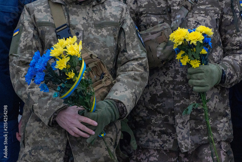 Canvas Print Ukrainian soldiers holding yellow and blue flowers