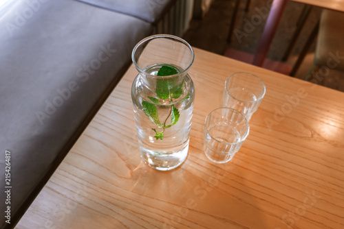 A glass carafe filled with fresh water and fresh mint leaves