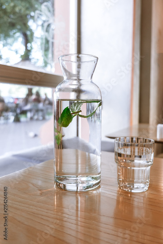 A glass carafe filled with fresh water and fresh mint leaves